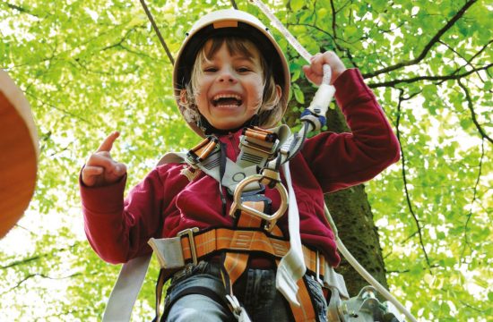 Bambina sul percorso a corde alte